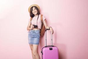 glad asiatisk kvinna turist på rosa bakgrund