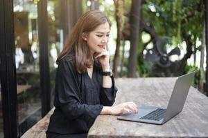 smart asiatisk kvinna arbetar med bärbar dator foto