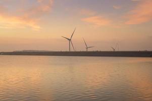 en bakgrund av vindkraftverk vid solnedgången. foto