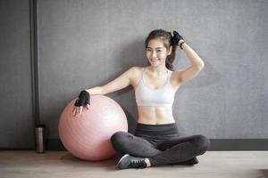 vacker asiatisk kvinna tränar i gymmet foto