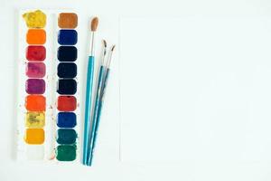 uppsättning akvarellfärger och penslar för målning på en vit bakgrund foto