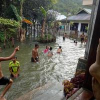 Indonesien, november 2021 - en grupp barn simmar i den översvämmade gården foto