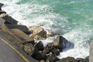 vågorna bryter på en stenig strand och bildar en spray. våg och stänk på stranden. vågor som slår mot stenar. foto
