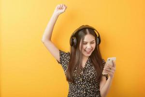 musikälskare kvinnan njuter med headsetet på gul bakgrund foto