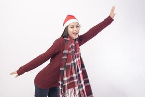 porträtt av ung leende kvinna som bär röd jultomtehatt isolerad vit bakgrund studio. foto