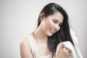 en kvinna torkar håret med en handduk efter att ha duschat