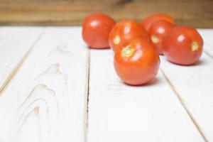 tomat på vit trä bakgrund. foto