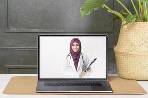 kvinnlig muslimsk läkare ringer videosamtal på socialt nätverk med patientrådgivning om hälsoproblem. foto