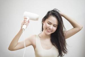 en kvinna torkar håret efter att ha duschat foto