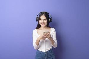 ung kvinna lyssnar på musik på lila bakgrund