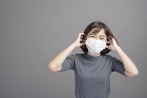 porträtt av ung vacker asiatisk kvinna som bär en kirurgisk mask över studiobakgrund covid19 pandemi och luftföroreningar foto
