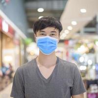 asiatisk man bär kirurgisk mask i köpcentrum