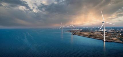 flygbild över vindkraftverken. grön ekologisk energiproduktion. vindkraftspark ekofält. offshore och onshore vindkraftverk grön energi till havs foto