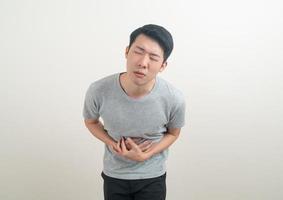 ung asiatisk man som har ont i magen foto