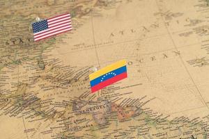 USA:s och Venezuelas flaggor på världskartan. konceptuellt foto, politik och världsordning foto