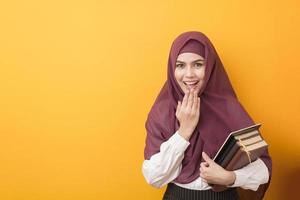 vacker universitetsstudent med hijab porträtt på gul bakgrund