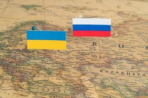 Rysslands och Ukrainas flaggor på världskartan. konceptuellt foto, politik och världsordning, politiska skillnader foto
