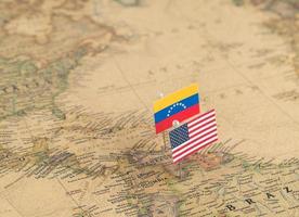 USA:s och Venezuelas flaggor på världskartan. konceptuellt foto, politik och världsordning foto