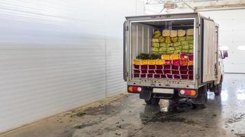 öppnade bakdörrarna på lastbilen lastad med rosenblommor. laddar blommor i lager för leverans foto