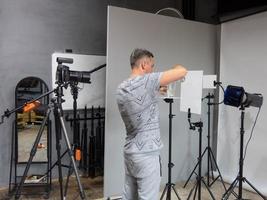 en ung fotograf förbereds för fotografering i studion. oavsiktlig fotografering foto