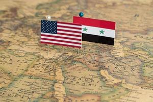 USA:s och Syriens flaggor på världskartan. konceptuellt foto, politik och världsordning, militär konflikt foto
