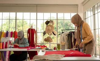 båda muslimska kvinnorna driver ett litet företag i sina egna hem. är design och skräddarsydda kläder. foto