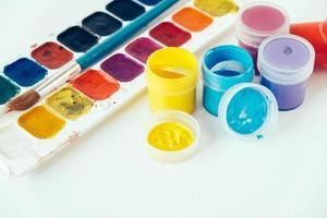 färgglada gouachefärger och pensel för målning på vit bakgrund foto