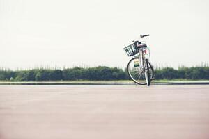 vintage tonad av cykel med korg på tom brygga, sommardag. foto