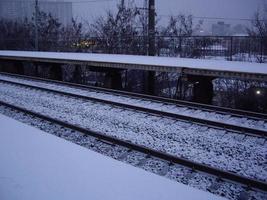 snötäckt järnvägsplattform på morgonen på vintern foto