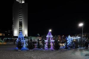 vladivostok, primorsky krai-13 januari 2020 - nattlandskap i den festliga staden. kvadrat med julbelysning och människor. foto