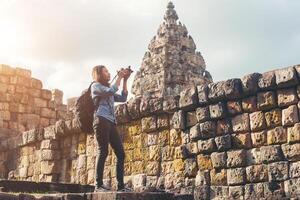 ung attraktiv kvinna fotograf turist med ryggsäck kommer att skjuta foto på antika Phanom rung tempel i Thailand.