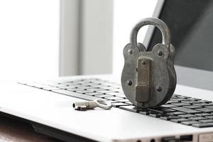 Internetsäkerhet koncept gamla hänglås och nyckel på bärbar dators tangentbord foto