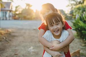 människor porträtt av ett känslomässigt ansiktsuttryck av leende och skratt av 6-åriga asiatiska syskonbarn. familjen friska och lycka barn leker tillsammans koncept foto