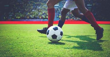 fotboll eller fotbollsspelare står med bollen på planen för att sparka fotbollen på fotbollsstadion, mjukt fokus foto