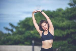 atletisk kvinna asiatisk uppvärmning och ung kvinnlig idrottare sitter på en träning och stretching i en park innan löpare utomhus, hälsosamt livsstilskoncept foto