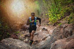 en man löpare av trail. och idrottares fötter iförda sportskor för traillöpning i skogen foto