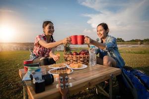 ett gäng asiatiska vänner som dricker kaffe och ägnar tid åt att göra en picknick på sommarlovet. De är glada och har roligt på semestern. foto