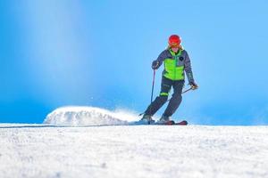 en bra skidåkare i aktion flyttar den dammiga snön till banan foto