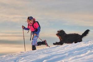 flicka under snöpromenad med sin stora kärlekshund foto