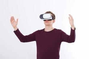upphetsad ung man i ett vr-headset, glasögon. virtuell verklighet isolerad på vit bakgrund. kopiera utrymme och mock up foto