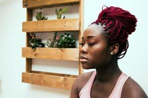 svart kvinna porträtt gör meditation foto