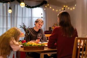 farfar, föräldrar, och de Tonårs flickor är Allt har middag tillsammans på Hem på jul natt foto