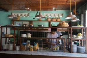 hue, vietnam -08172015- folk lagar mat vid ett öppet kök på en vietnamesisk restaurang. bänkskiva i marmor, ingredienser, såser och porslin. foto