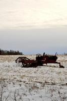 vinter i Manitoba - en strängläggare som sitter i ett snötäckt fält foto