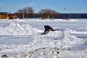vinter i Manitoba - sittande på en snöbank och snörning på skridskor foto