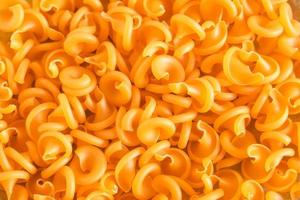 orange pasta som bakgrundsbild. toppvy. kopiera, tomt utrymme för text foto