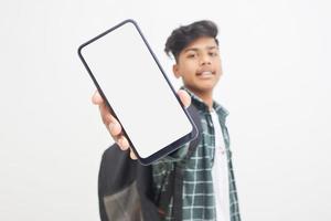 ung indisk college student visar smartphone skärm på vit bakgrund. foto