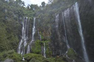 landskap av vattenfallet underifrån. sommar och vattenfall bakgrund. plats vid tumpak sewu vattenfall, indonesien foto