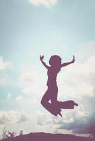 siluett av en vacker flicka hoppar foto
