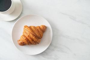 färsk croissant på vit platta foto
